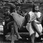 John Cleese reads a newspaper while Graham Chapman smokes a pipe on the set of Holy Grail