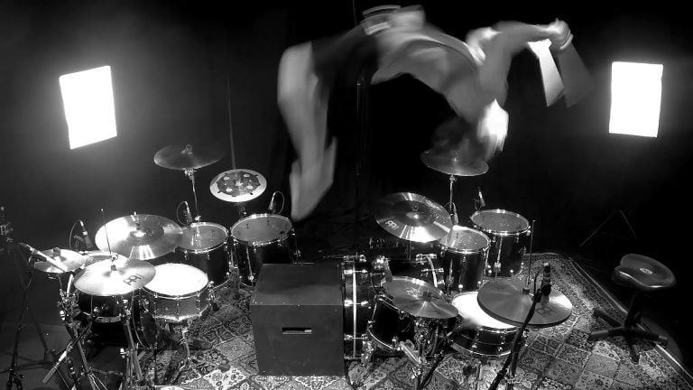 Drummer does a backflip between 2 drum sets, while soloing